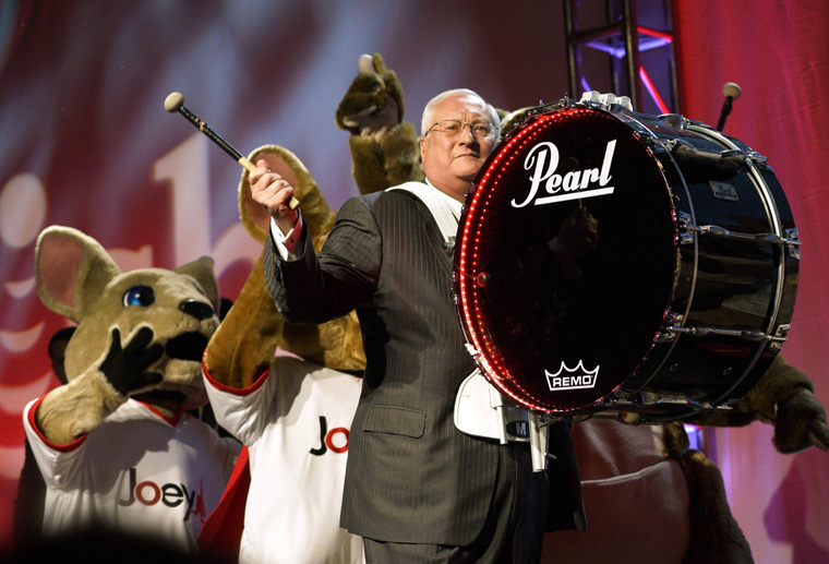 Joe Clayton, CEO of Dish, arrives on stage banging a bass drum followed by company mascots during the Dish news conference at the International Consumer Electronics show (CES) in Las Vegas